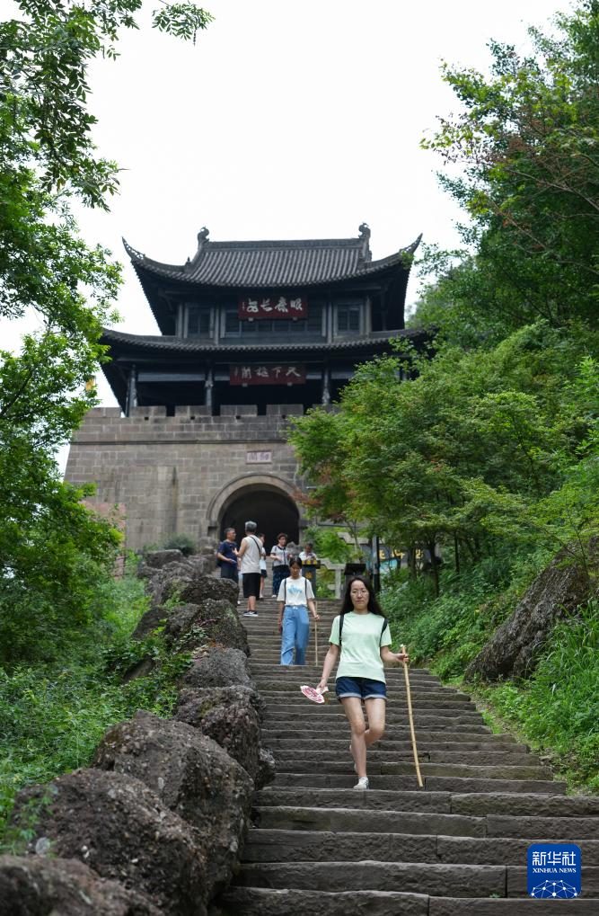 剑门关关楼近景，游客沿石阶古道下行
